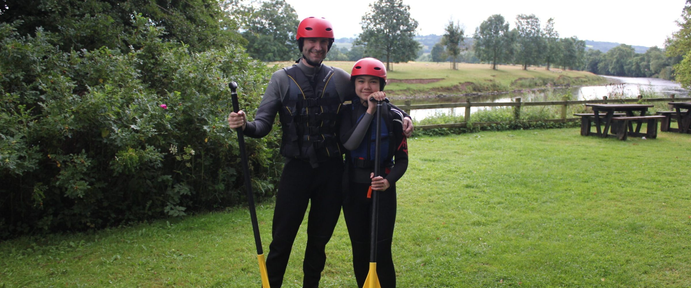 father and daughter posing with paddles
