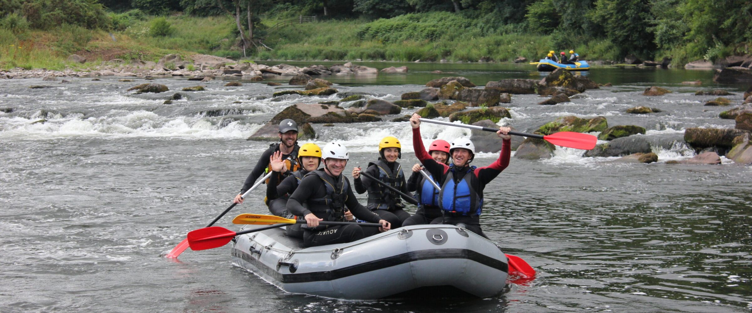 a group of people white water rafting in lake district, cumbria