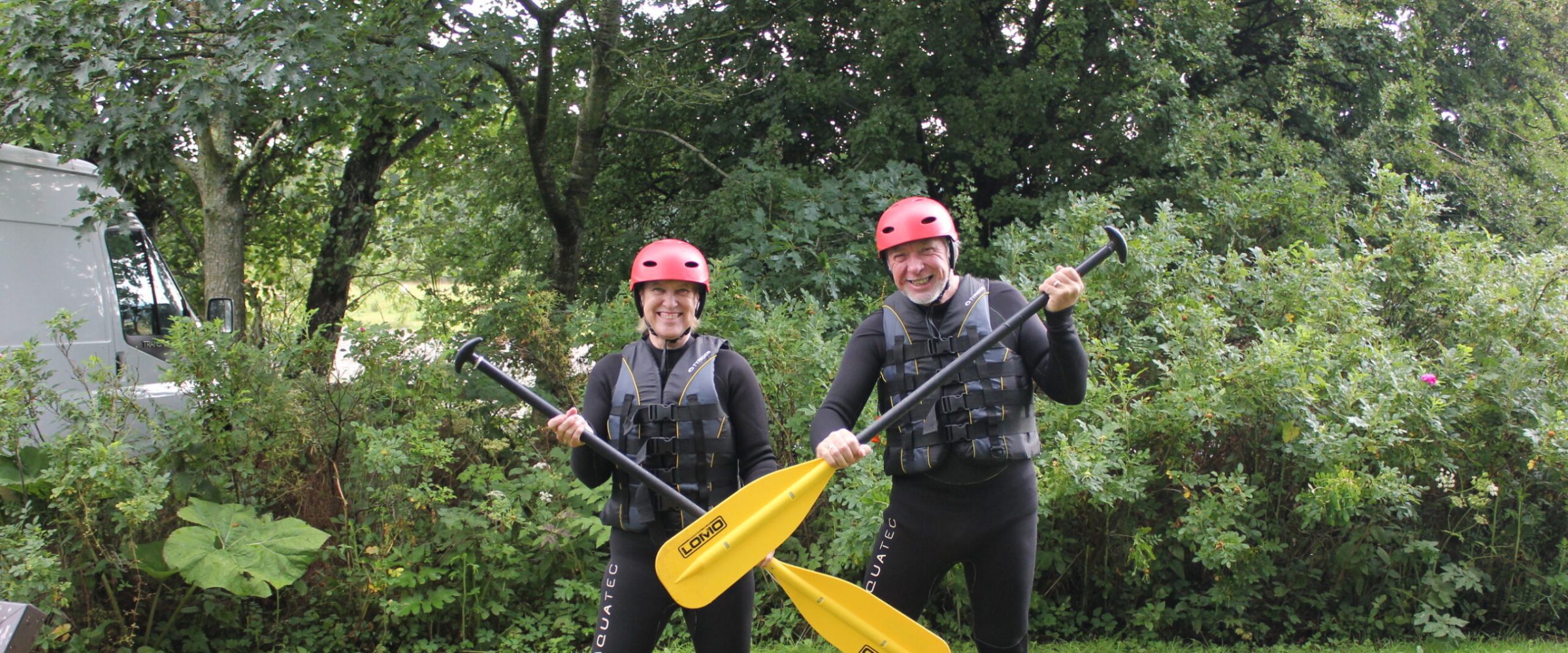 a man and a woman posing with paddles