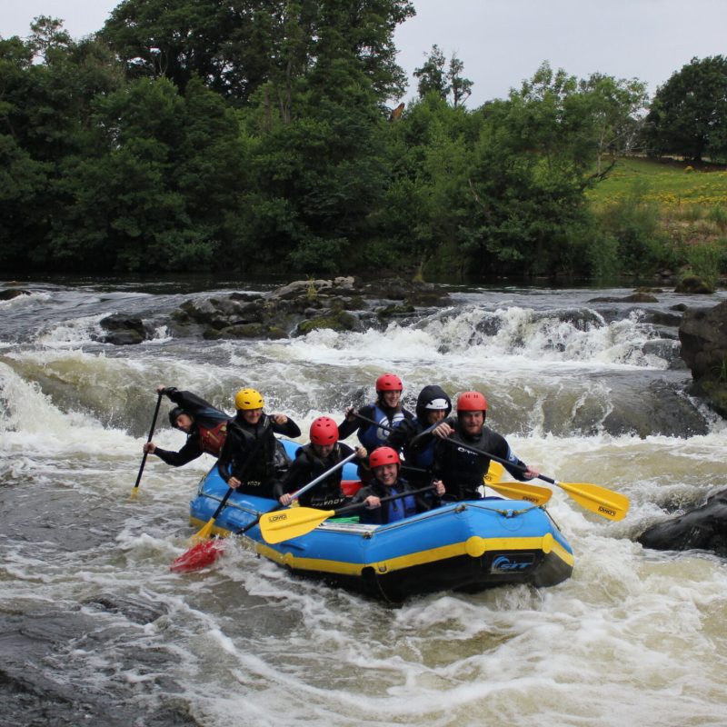 a group of people white water rafting in lake district, cumbria