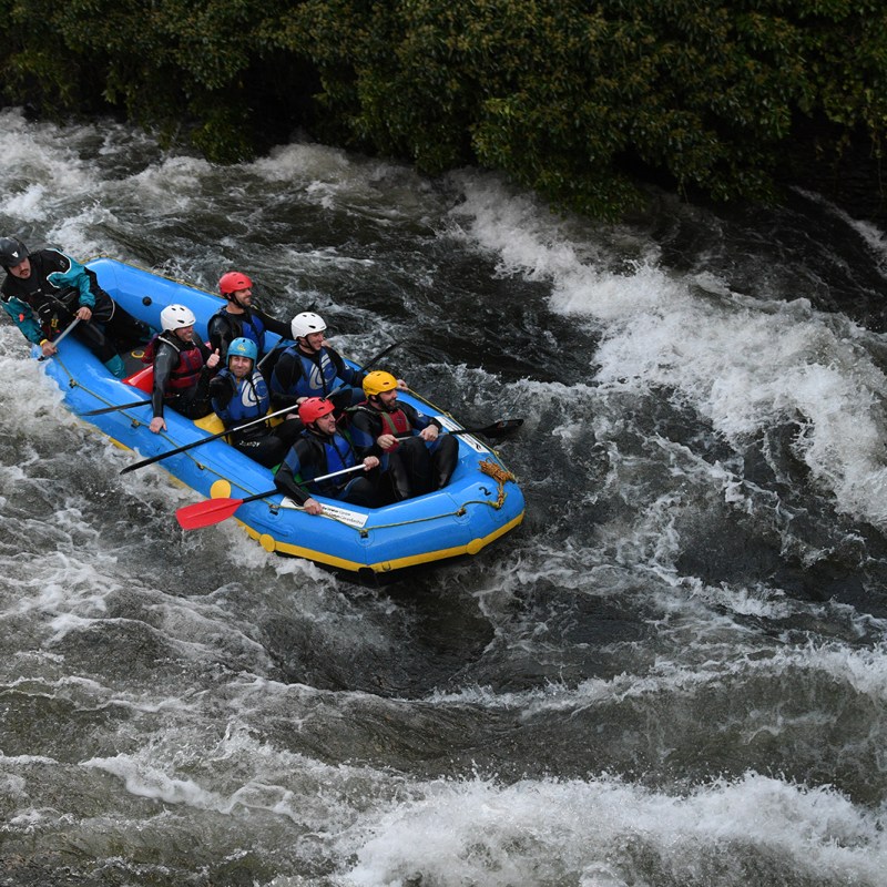 a group of people white water rafting in lake district, cumbria