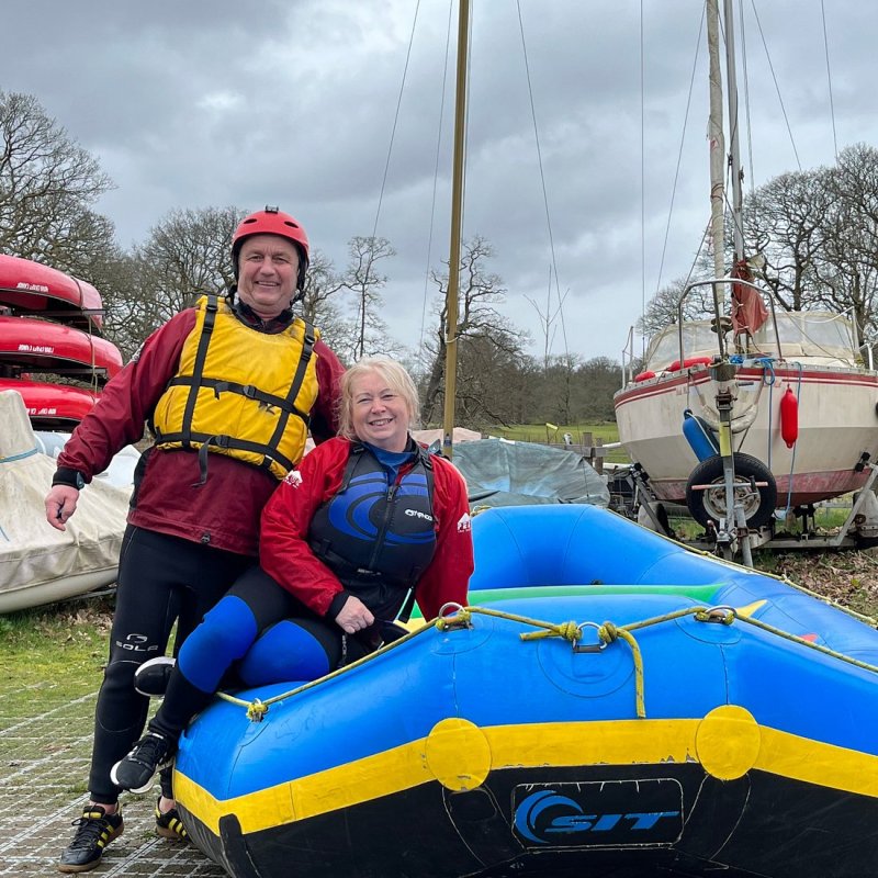 a man and a woman posing for a photo on a raft